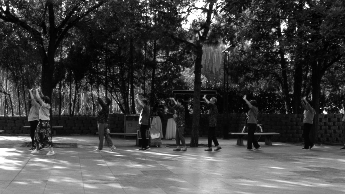 a black and white photo of a group of people in a park